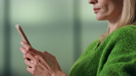 Thoughtful-woman-messaging-phone-in-office-portrait.-Lady-hands-tapping-screen