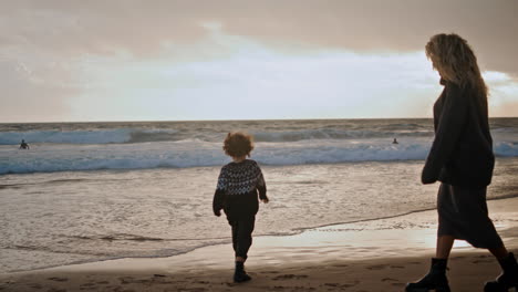 Little-boy-playing-shore-on-sunset.-Joyful-son-spending-weekend-with-mother.