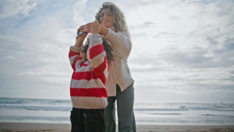Cute-boy-playing-kite-with-mother-on-beach.-Caring-parent-teaching-helping-child