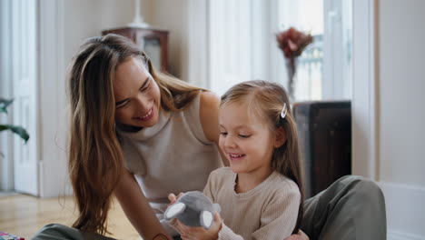 Cute-family-playing-bunny-at-cozy-home-closeup.-Positive-woman-embracing-girl