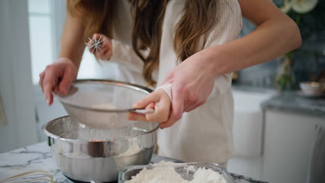 Mother-daughter-hands-cooking-dough-at-home-close-up.-Baby-making-food-with-mom