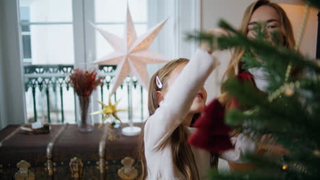 Tender-woman-giving-xmas-toy-girl-indoors-closeup.-Mom-decorating-with-daughter
