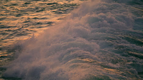 Dusk-water-breaking-by-marine-rocks-outdoors-close-up.-Sea-waves-covering-stone
