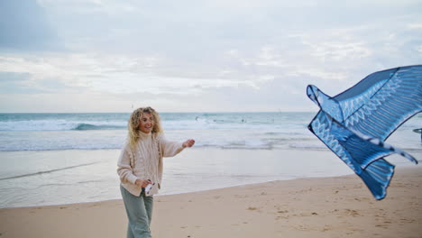Happy-woman-holding-kite-string-on-beach.-Carefree-mother-enjoying-weekend