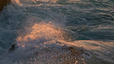 Stormy-ocean-crashing-on-sunlight-rocks-outdoors-close-up.-Foaming-sea-breaking