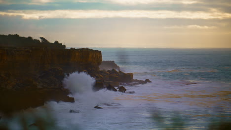 Beautiful-ocean-waves-crashing-cliffs-in-morning.-Serene-seascape-at-cloudy-sky.