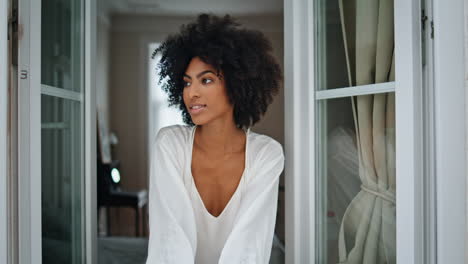 Relaxed-lady-looking-window-at-weekend-morning.-Dark-skin-woman-staring-camera