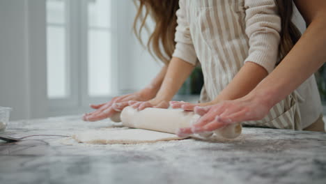 Woman-girl-hands-cooking-dough-at-home.-Unrecognizable-family-flatten-pastry