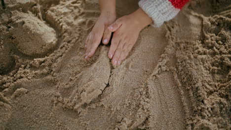 Kid-hands-building-sand-castle-on-seashore-weekend.-Creative-boy-enjoying-game