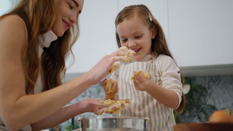 Funny-baby-playing-dough-at-cook-place.-Mother-removing-pastry-from-kid-hands