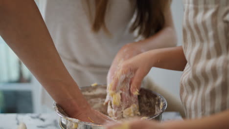 Mother-daughter-hands-kneading-dough-home-closeup.-Unknown-family-cooking-cake