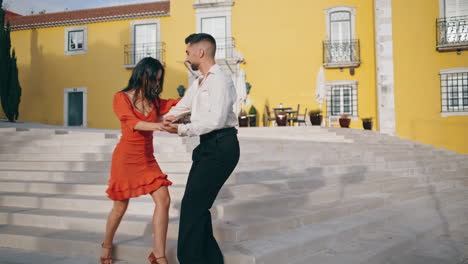 Latin-performers-practicing-dance-on-town-stairs.-Happy-couple-dancing-outdoors.