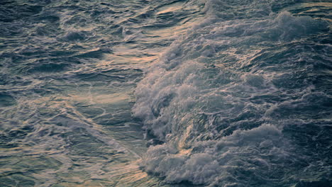 Swirling-ocean-foaming-at-morning-nature-closeup.-Waves-breaking-at-shoreline