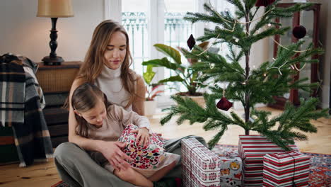 Happy-family-getting-presents-at-cozy-home.-Girl-receiving-gifts-from-mother