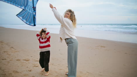 Family-playing-kite-together-on-windy-seaside.-Happy-mother-spending-weekend
