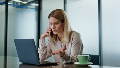 Emotional-businesswoman-calling-cellphone-at-office-closeup.-Angry-woman-arguing