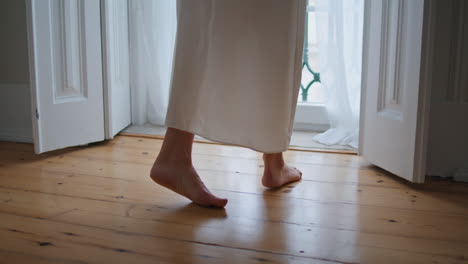 Tender-woman-legs-stepping-at-morning-home-closeup.-Unknown-girl-moving-at-floor