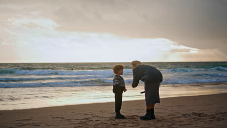 Parent-scolding-little-boy-on-beach.-Young-mother-talking-boy-resting-shore