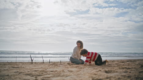 Preschool-boy-playing-beach-with-young-mother.-Happy-parent-kid-resting-together