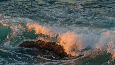 Hohe-Wellen-Rollen-Dunkle-Felsen-Im-Sonnenlicht,-Natur,-Nahaufnahme.-Ozeanwasser-Bricht