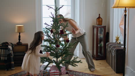 Emotional-family-playing-at-New-Year-tree-room.-Mother-hiding-from-daughter