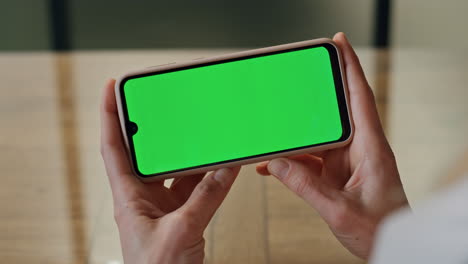 Lady-boss-fingers-hold-mockup-telephone-at-office.-Woman-watching-green-screen