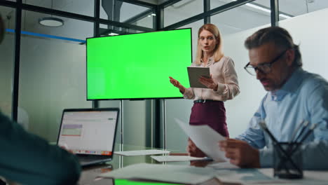 Leader-woman-presenting-mockup-project-indoors.-Lady-pointing-on-greenscreen