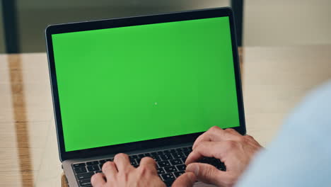Man-hands-typing-chromakey-laptop-at-workplace-closeup.-Boss-pushing-buttons
