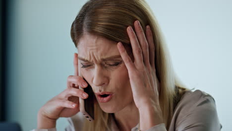 Stressed-entrepreneur-calling-phone-at-workroom.-Confused-manager-facepalming
