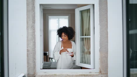 Relaxed-woman-enjoying-espresso-cup-window-frame.-African-lady-rest-with-coffee