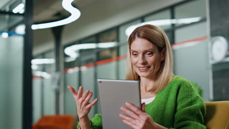 Happy-employee-video-chatting-tablet-in-workplace-closeup.-Lady-gesturing-hand