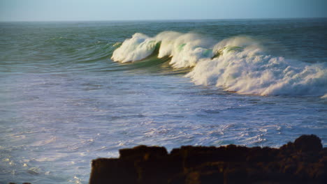 Huge-ocean-wave-rolling-in-slow-motion.-Scenic-foaming-sea-swelling-on-sunny-day