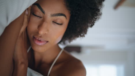 Serene-woman-sleeping-pillow-hotel-closeup.-African-girl-opening-eyes-at-morning