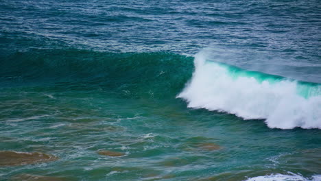 Turquoise-ocean-wave-swelling-in-slow-motion.-Foamy-powerful-barrel-rolling