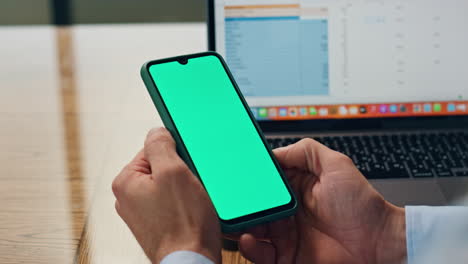 Employee-hands-holding-greenscreen-telephone-at-office-closeup.-Man-using-phone