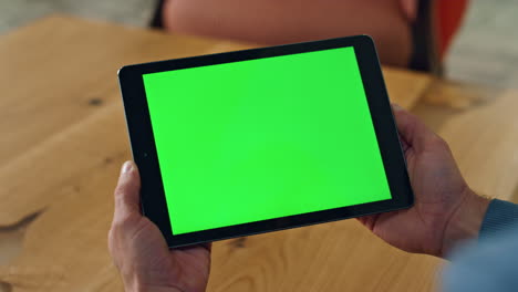 User-holding-chromakey-computer-indoors-closeup.-Man-reading-template-device