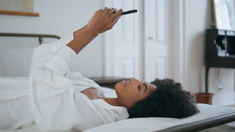 Laying-woman-messaging-phone-at-bedroom-close-up.-Girl-texting-email-resting-bed