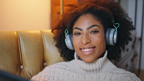 Cheerful-model-listening-headphones-portrait.-Happy-curly-woman-smiling-camera
