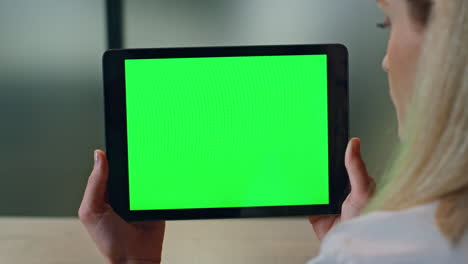 Closeup-lady-watching-greenscreen-tablet-at-office.-Woman-hands-holding-computer