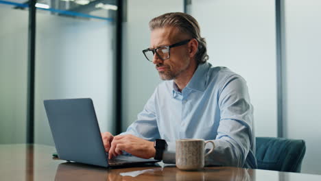 Focused-businessman-texting-laptop-at-office-closeup.-Eyeglasses-ceo-man-working