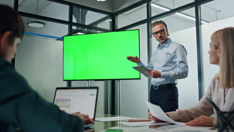 Businessman-making-chromakey-presentation-office.-Coach-pointing-at-green-screen