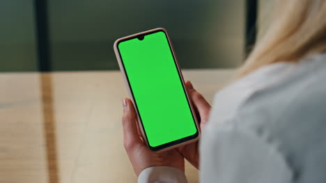 Lady-looking-green-display-phone-close-up.-Woman-hands-holding-mockup-cellphone