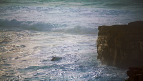 Storming-waves-rolling-cliff-seashore.-Foamy-ocean-splashing-washing-rocky-coast