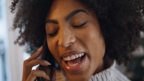 Laughing-girl-phone-call-indoors-closeup.-Smiling-curly-lady-talking-emotionally