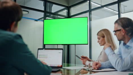 Business-partners-working-green-screen-tv.-Closeup-people-listening-conference