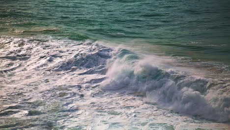 Foaming-surf-rolling-sea-shore-on-sunny-day.-Huge-waves-breaking-surface-splash