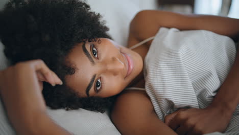Happy-lady-wakeup-bedroom-portrait.-African-woman-looking-camera-lying-bed-alone