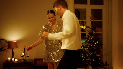 Romantisches-Paar-Tanzt-Weihnachtsbaum-Im-Inneren,-Nahaufnahme.-Frau-Und-Mann-Bewegen-Sich-Am-Abend