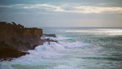 Ocean-washing-coastal-cliffs-on-gloomy-day.-Stormy-sea-breaking-rocks-in-evening