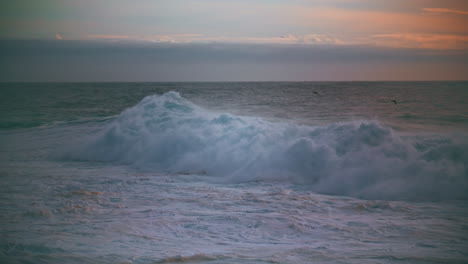 Huge-sea-wave-foaming-at-morning-skyline.-Powerful-surf-rolling-breaking-shallow